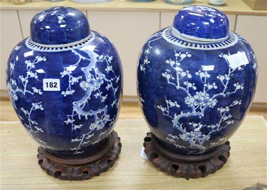 A pair of Chinese prunus pattern vases and covers with hardwood stands H.41cm